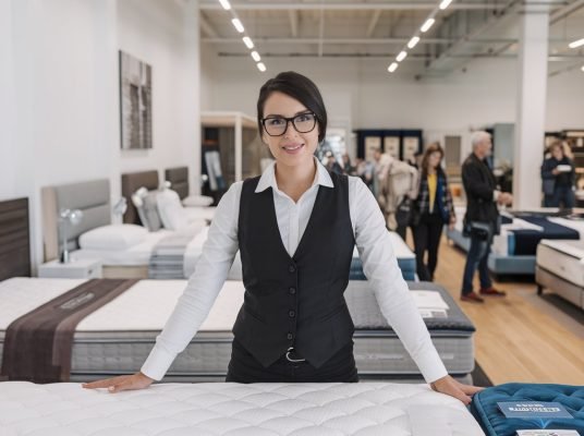 a-photo-of-a-woman-salesperson-in-a-mattress-showr-0ExSkyV-QWetM6m4s9TlnA-sX2hIdSBRrWz2d-YAdYwUQ